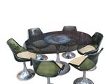 four chairs around a round table with a glass top