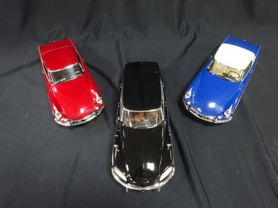 three toy cars that are sitting on a black surface