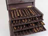 a wooden box filled with cigars on a white surface