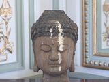 une statue représentant une tête posée sur une table devant un miroir