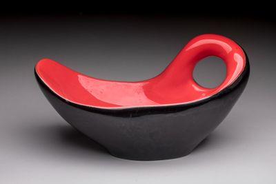 a black and red bowl with a red handle
