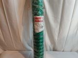 un tube en plastique vert, emballé dans du plastique, posé sur une surface blanche