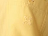the man is wearing a yellow shirt with a white monogram on it