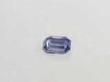 a blue sapphire stone on a white surface