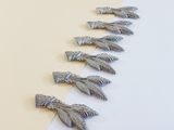 several silver colored feathers are lined up on a white and yellow background