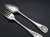 two spoons and a fork on a black surface