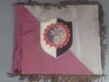 a pink and white flag with a crest on it