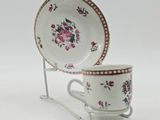 two cups and a saucer on a stand on a white background