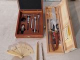 une boîte en bois contenant un couteau, une fourchette, un aiguiseur de couteaux et d'autres objets