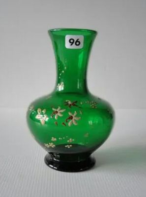 un vase en verre vert orné de fleurs dorées