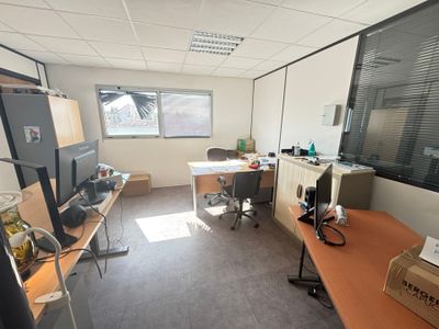 une salle avec de nombreux bureaux et une grande fenêtre