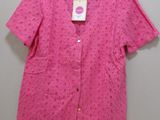 a pink shirt hanging on a hanger on a wall