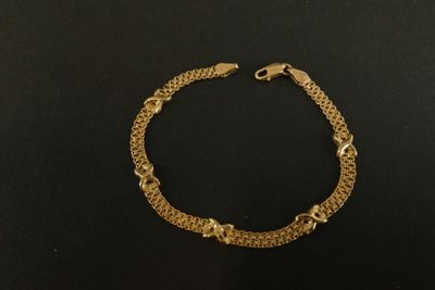 un bracelet en or sur une surface noire