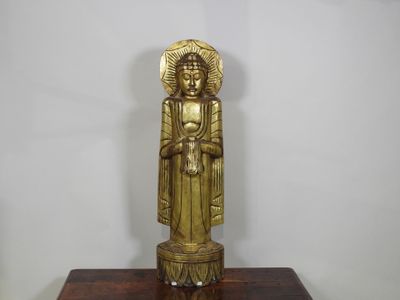 statue en laiton représentant une femme tenant un bébé dans ses bras, posée sur un socle en bois