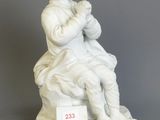 statue of a woman sitting on a chair holding a baby