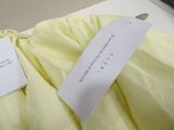 a label on a yellow dress with a tag on it