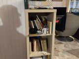 a book shelf with books on top of it in a room