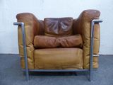 a brown leather chair with a brown pillow on it