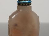 a small glass bottle with a red lid on a table