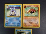 three pokemon cards are sitting on a table next to each other