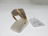 gros plan d'une bague en or avec des diamants sur une surface blanche