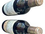 two bottles of wine sitting next to each other on a table