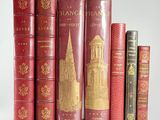 several old books are lined up on a shelf in front of a white background