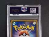 the pokemon card is in a clear plastic holder on a table