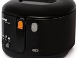 un gros plan d'un appareil de cuisson noir et orange posé sur une surface blanche