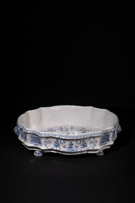 an old blue and white bowl sitting on top of a black table