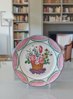 une assiette posée sur une table, sur laquelle se trouve un panier de fleurs