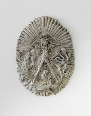 une image représentant un médaillon en argent sur lequel figure une femme tenant une épée