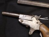 a gun that is sitting on a table next to a knife