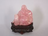 une statue rose représentant une personne assise sur une table