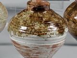trois vases posés l'un à côté de l'autre sur une table