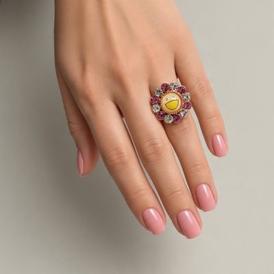 an image of a woman ' s hand with a pink manicure and a yellow and white ring