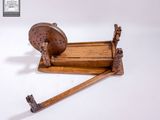 une toupie en bois munie d'un manche en bois, posée sur une surface blanche