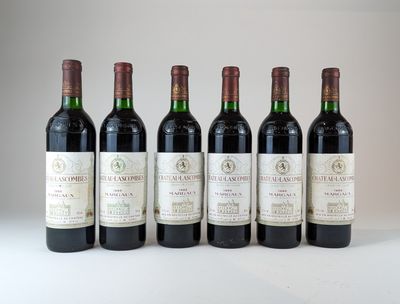 six bouteilles de vin sont alignées sur une surface blanche