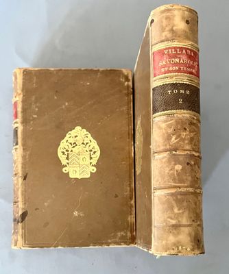 un vieux livre posé sur une table blanche à côté d'un livre