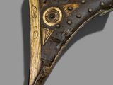 an image of a bronze and wood object on a gray background