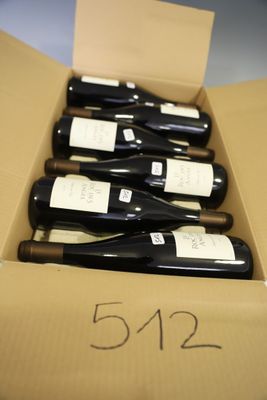 six bottles of wine are in a cardboard box on a table