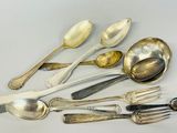 a lot of silver spoons and forks on the table