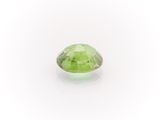 a close up of a green gemstone on a white surface
