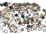 a pile of rings and other jewelry on a white surface