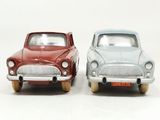 two toy cars sitting next to each other on a white surface