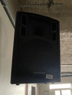 a black speaker that is hanging from the ceiling