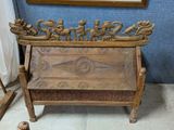 un banc en bois orné de sculptures, placé devant un miroir