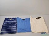 Trois t-shirts pour hommes sont alignés sur une table