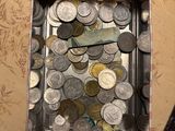 a tin of coins sitting next to a book on a table