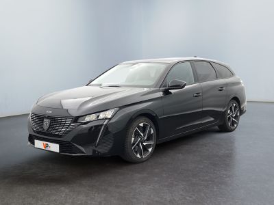 Une voiture grise est garée dans une pièce aux murs blancs.